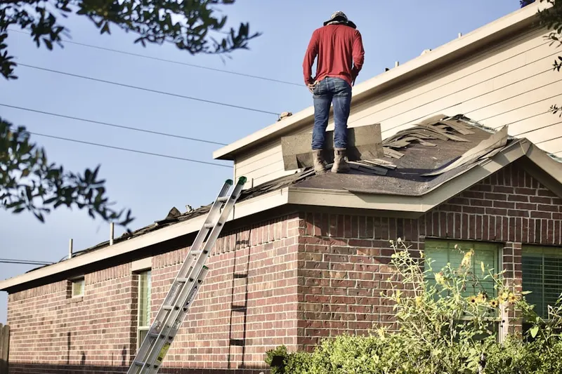 Professional roofer working on a residential roof in Yates Village